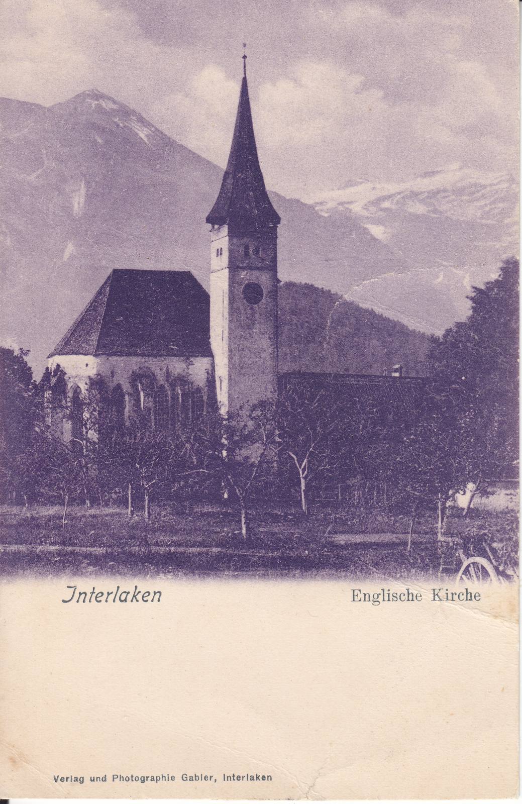The old monastery church at Interlaken, with its tall tower and spire, seen across an orchard
