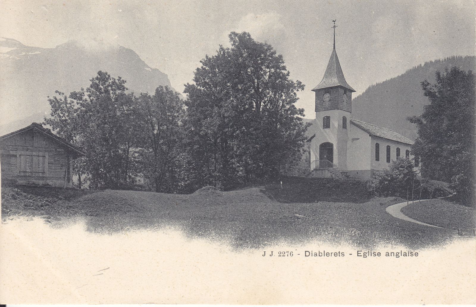 The English church at Les Diablerets, seen among trees below the mountains